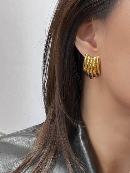 Elegant gold ribbed stud earrings with hammered finish.