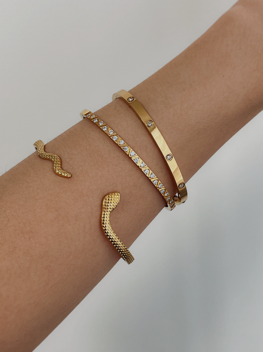 elegant trio of golden bangles with gemstone accents on a wrist