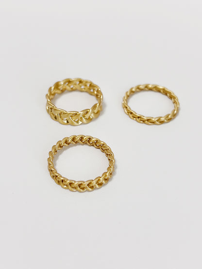 Three gold braided-style rings on a white background