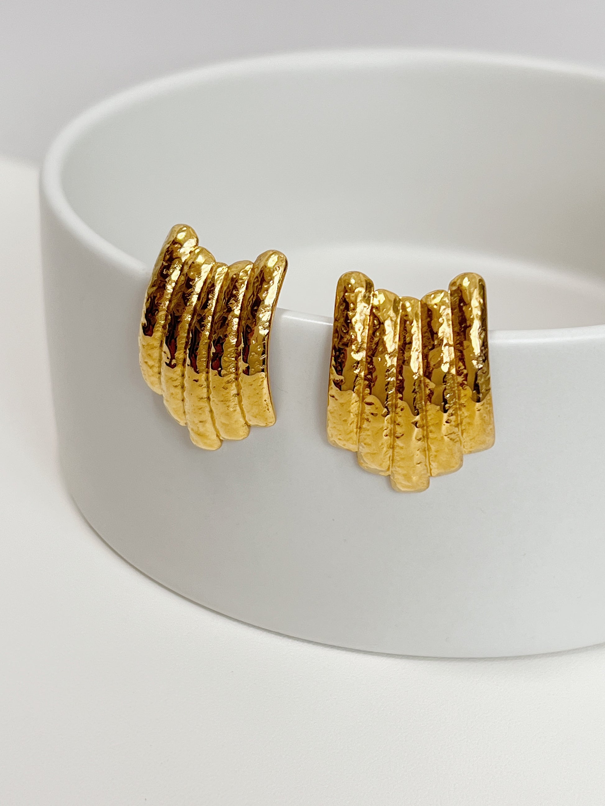 Fashionable gold earrings featuring a unique ribbed look.