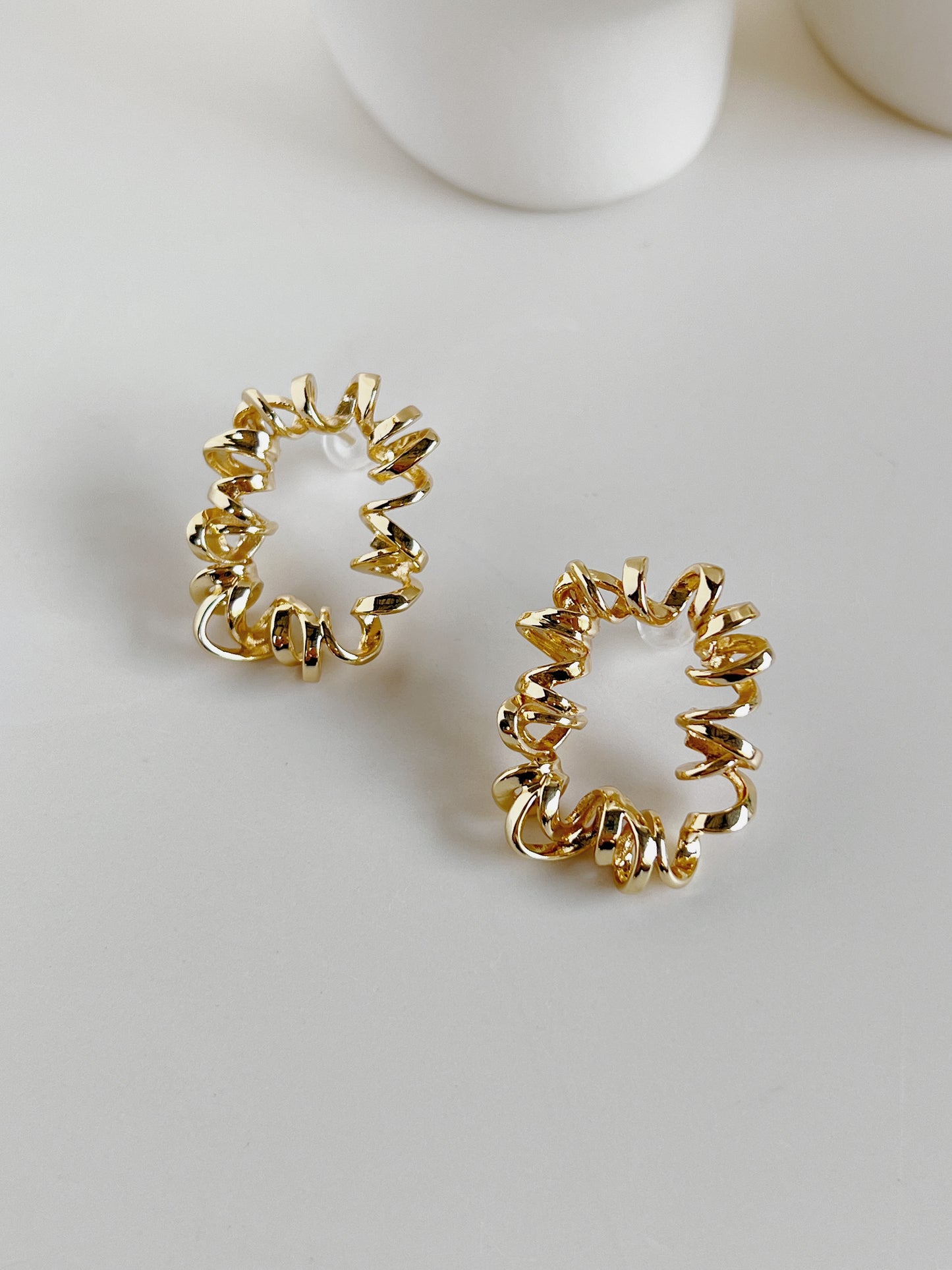 Gold spiral earrings on a white background