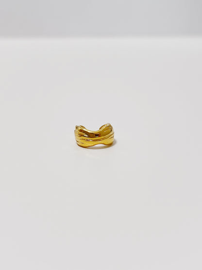 Gold curve ear cuff on a light gray background