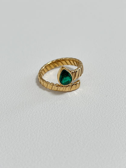 Gold ring with emerald teardrop gemstone, luxury jewelry for special occasions.