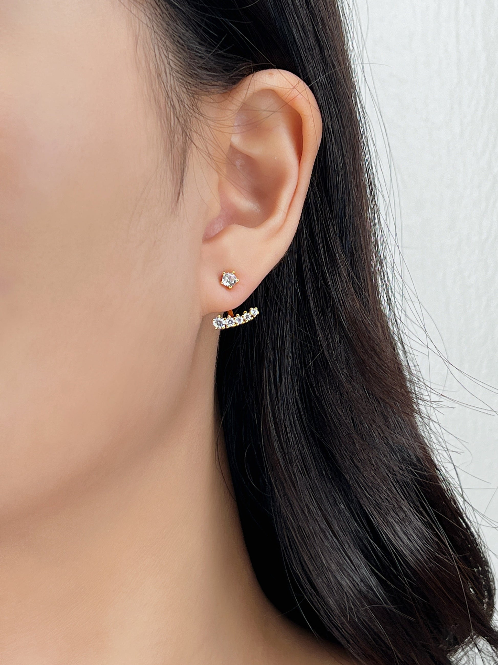 Close-up of an ear wearing a small earring with a blurred background