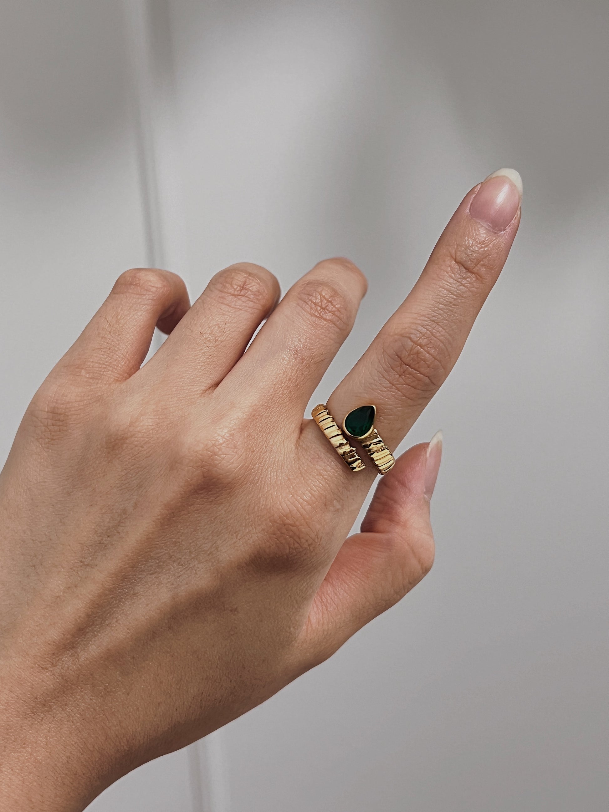 Luxury gold ring with emerald teardrop, high-quality jewelry for special events.