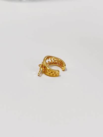 Gold cuff earring on a light gray background
