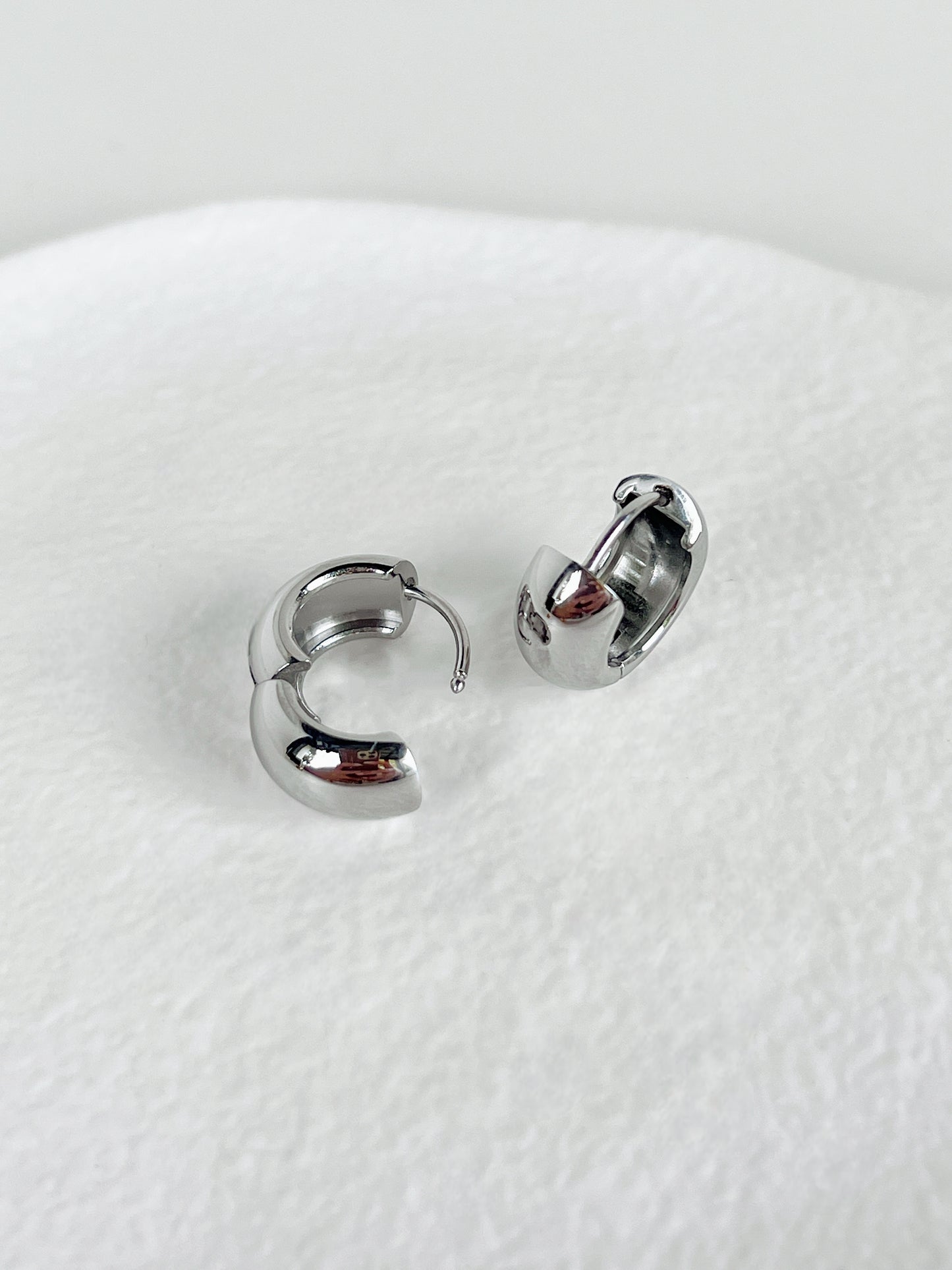 Pair of silver hoop earrings on a white background