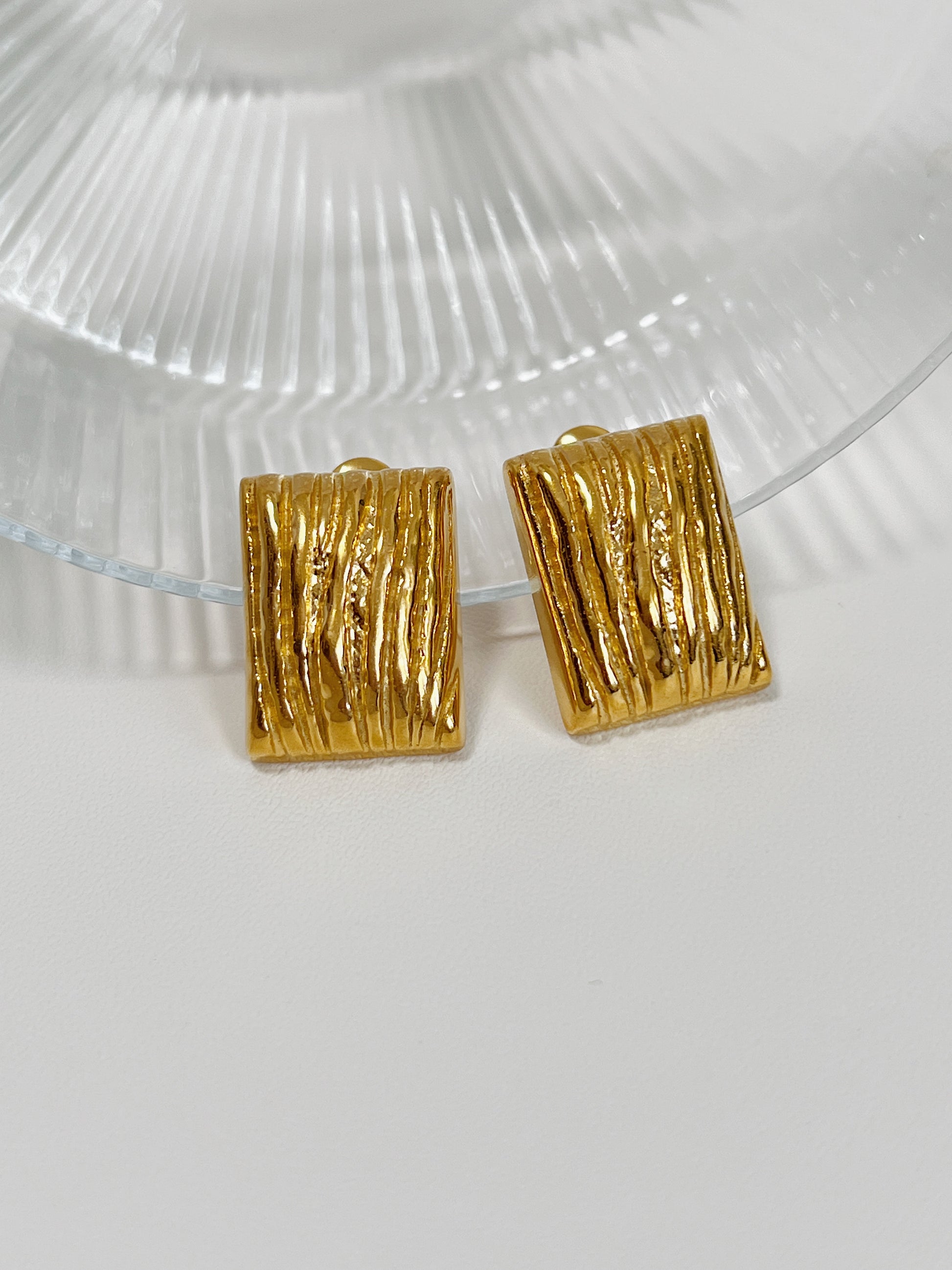 Women's gold rectangular stud earrings with unique textured pattern