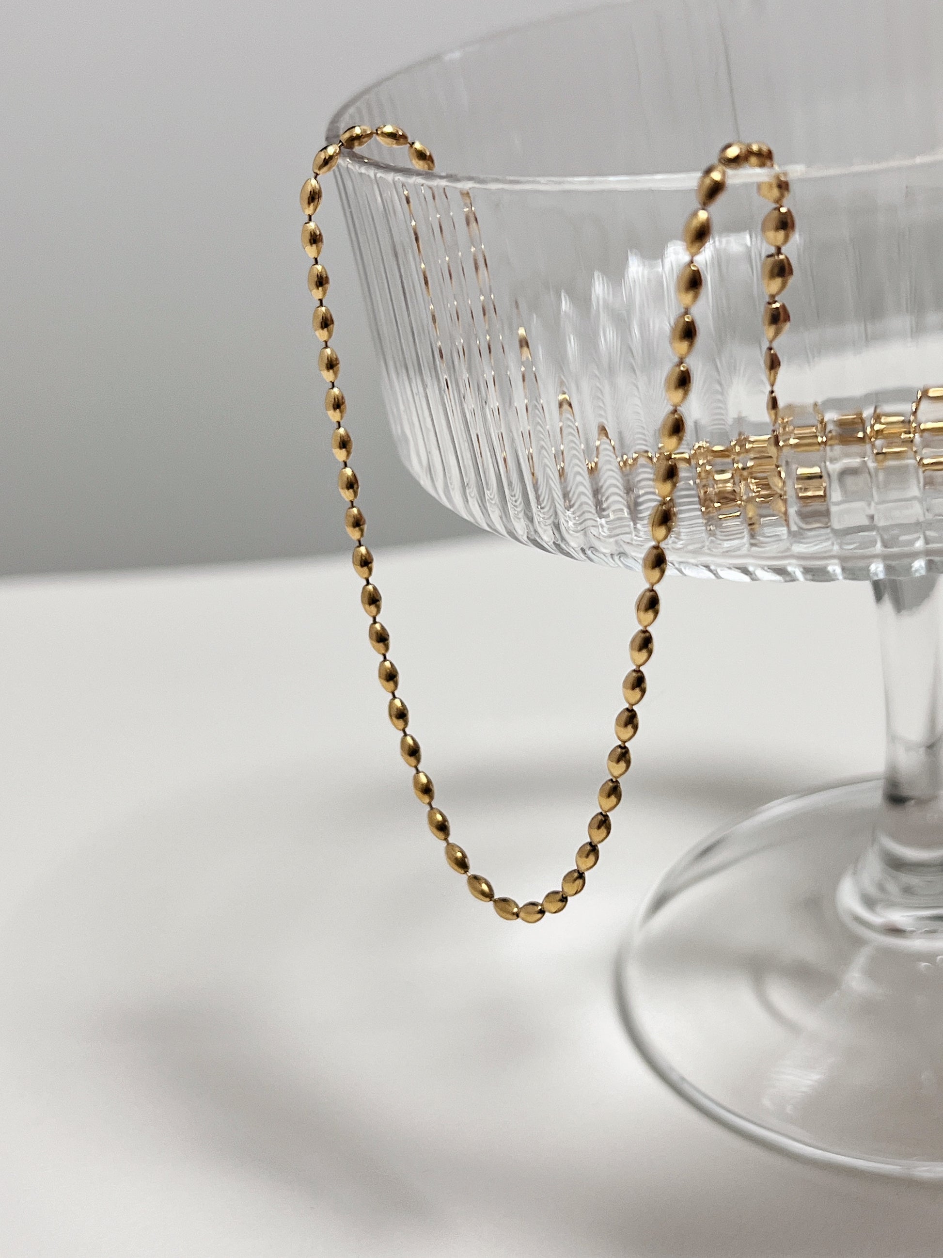 Fashionable gold chain necklace, rice bead design, women's jewelry, versatile accessory, Gold rice beaded chain, elegant jewelry, stylish layering piece, luxury accessory