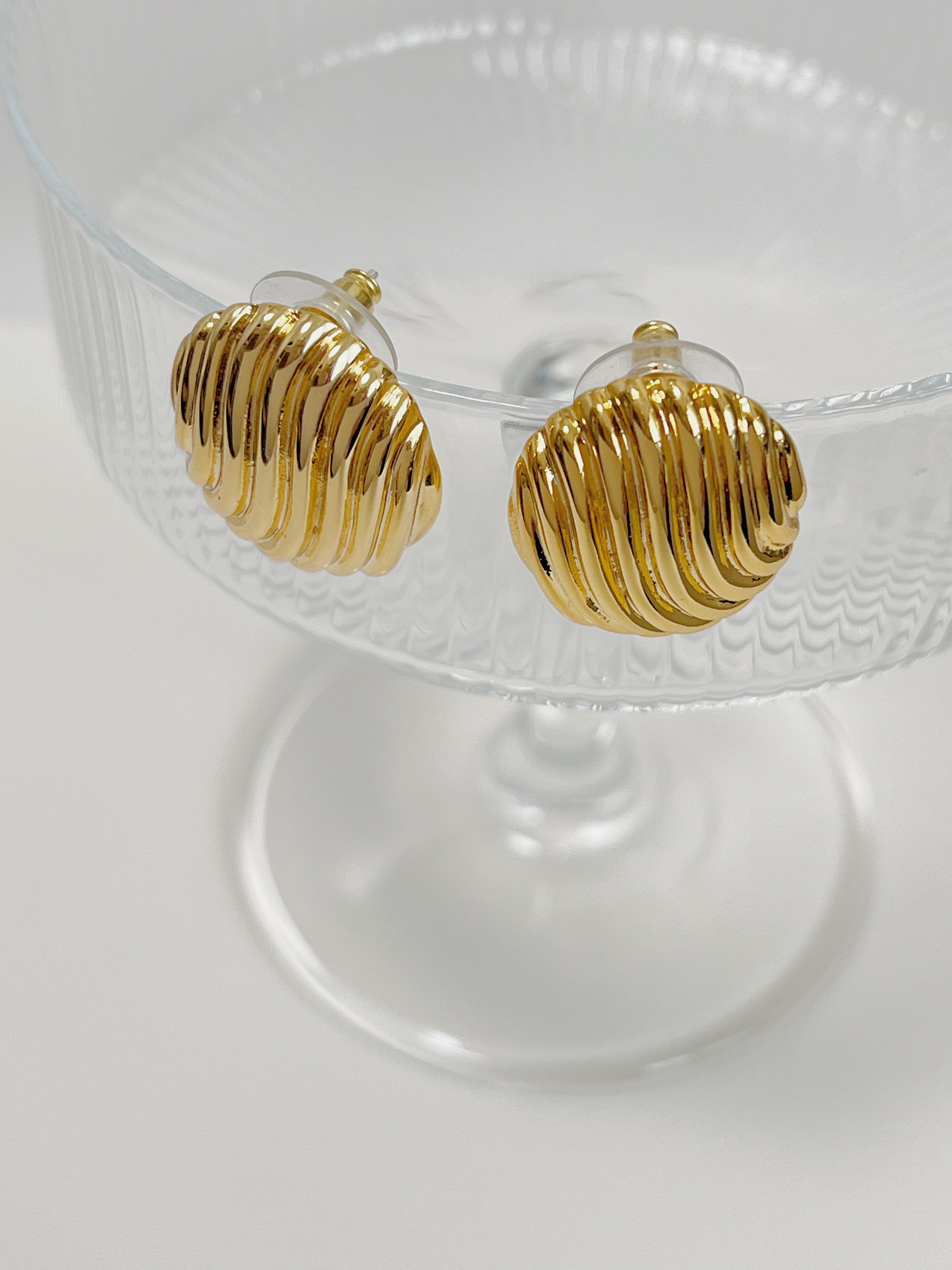 Gold ribbed oval earrings with a polished finish.