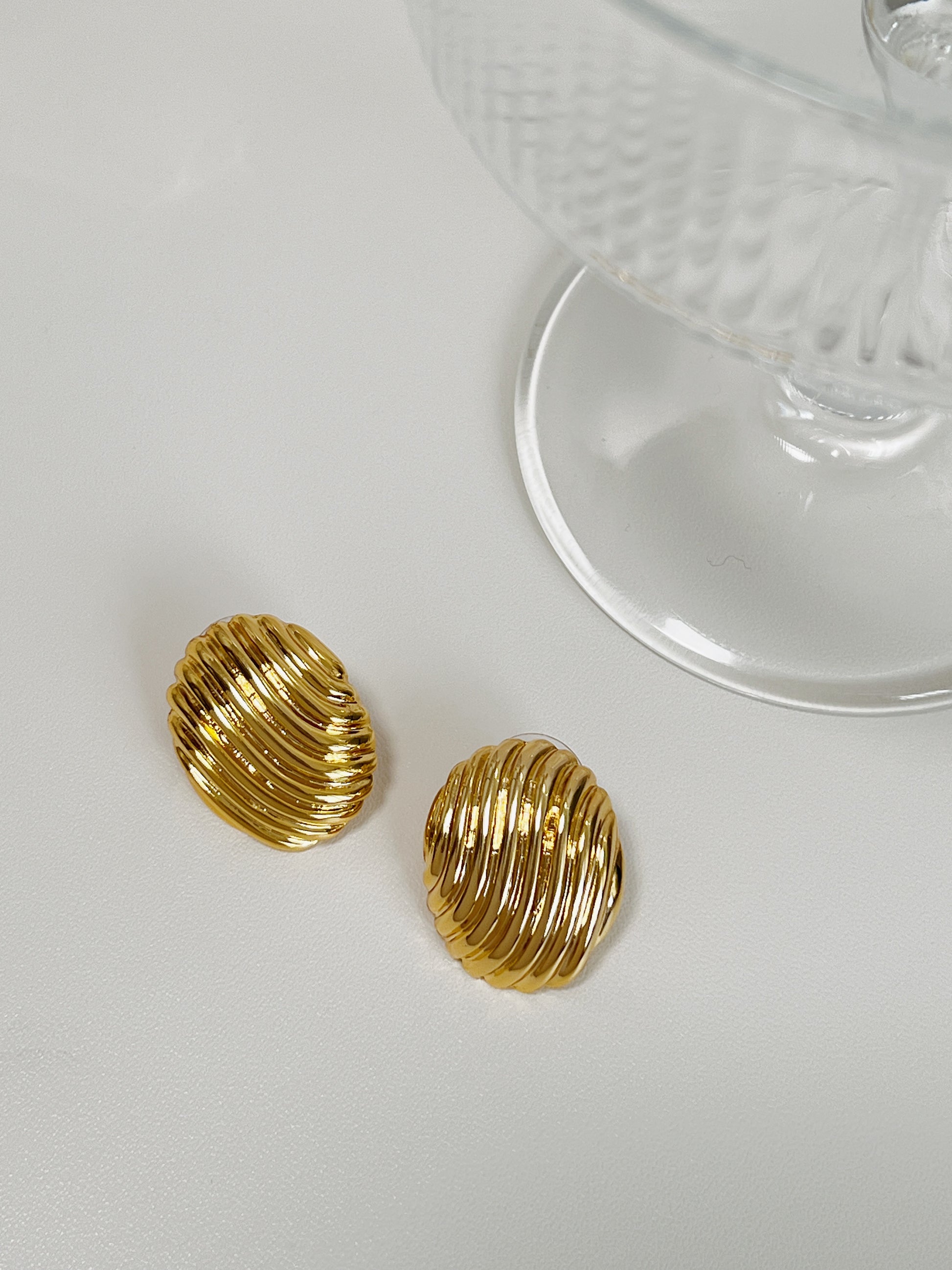 Stylish gold ribbed oval earrings for formal occasions.