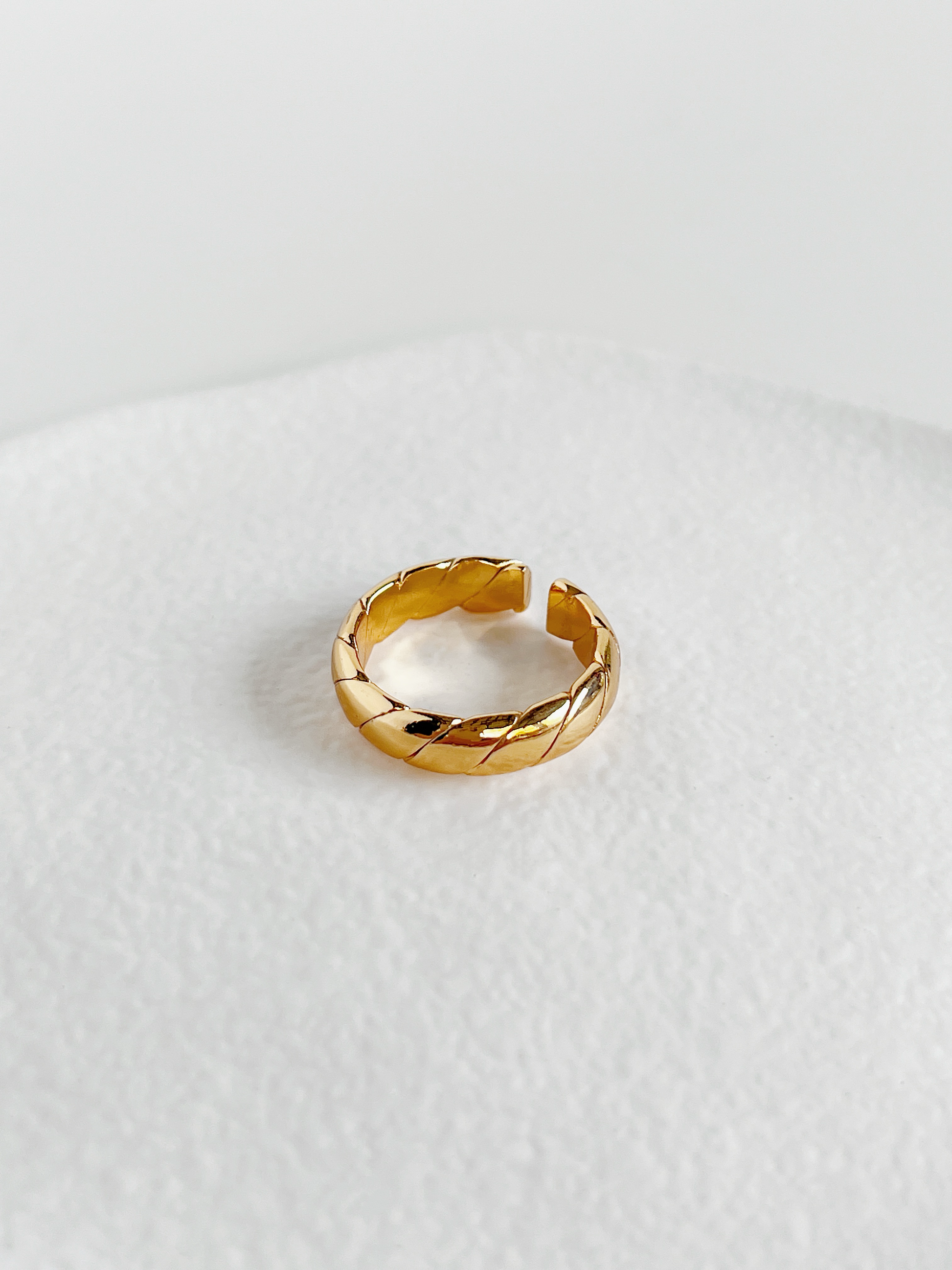 Polene gold twill high shine ring macro shot highlighting the uniform diagonal twisted channels