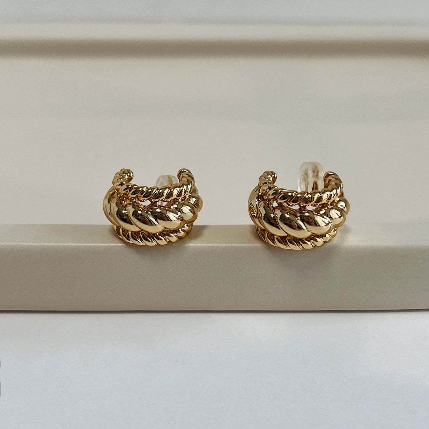 Waterproof gold clip-on earrings with a secure, invisible-fit mechanism.