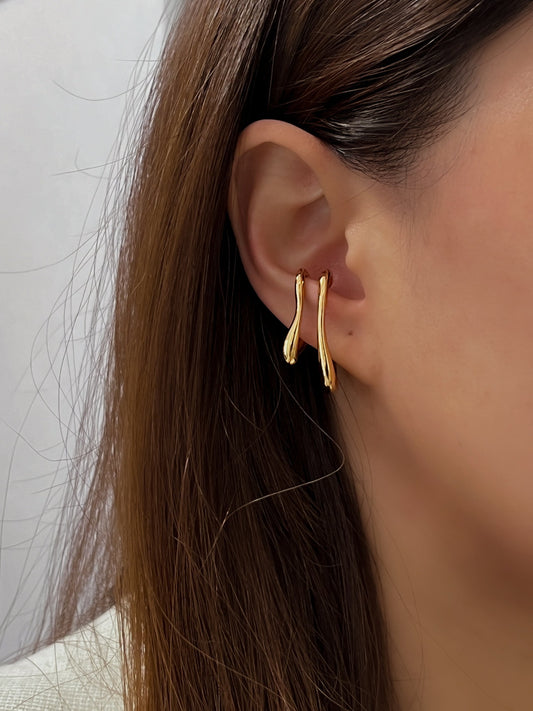 Gold ear lobe cuff earrings with a modern, abstract aesthetic.