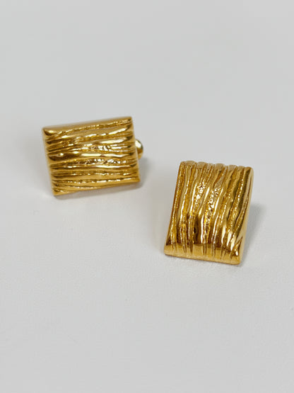 Women's gold rectangle stud earrings with a modern textured design.