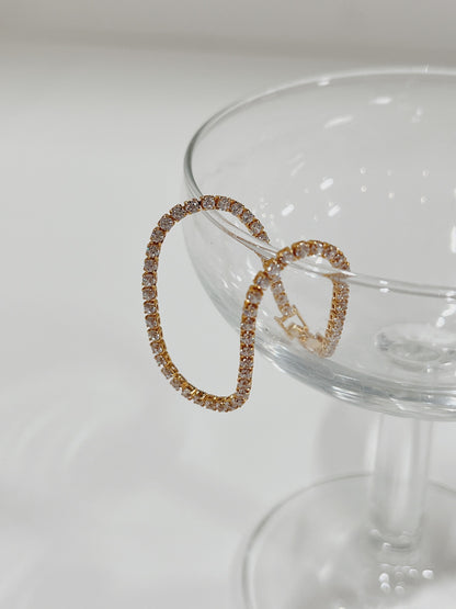 Gold tennis bracelet adorned with diamonds, elegantly draped over a glass bowl.