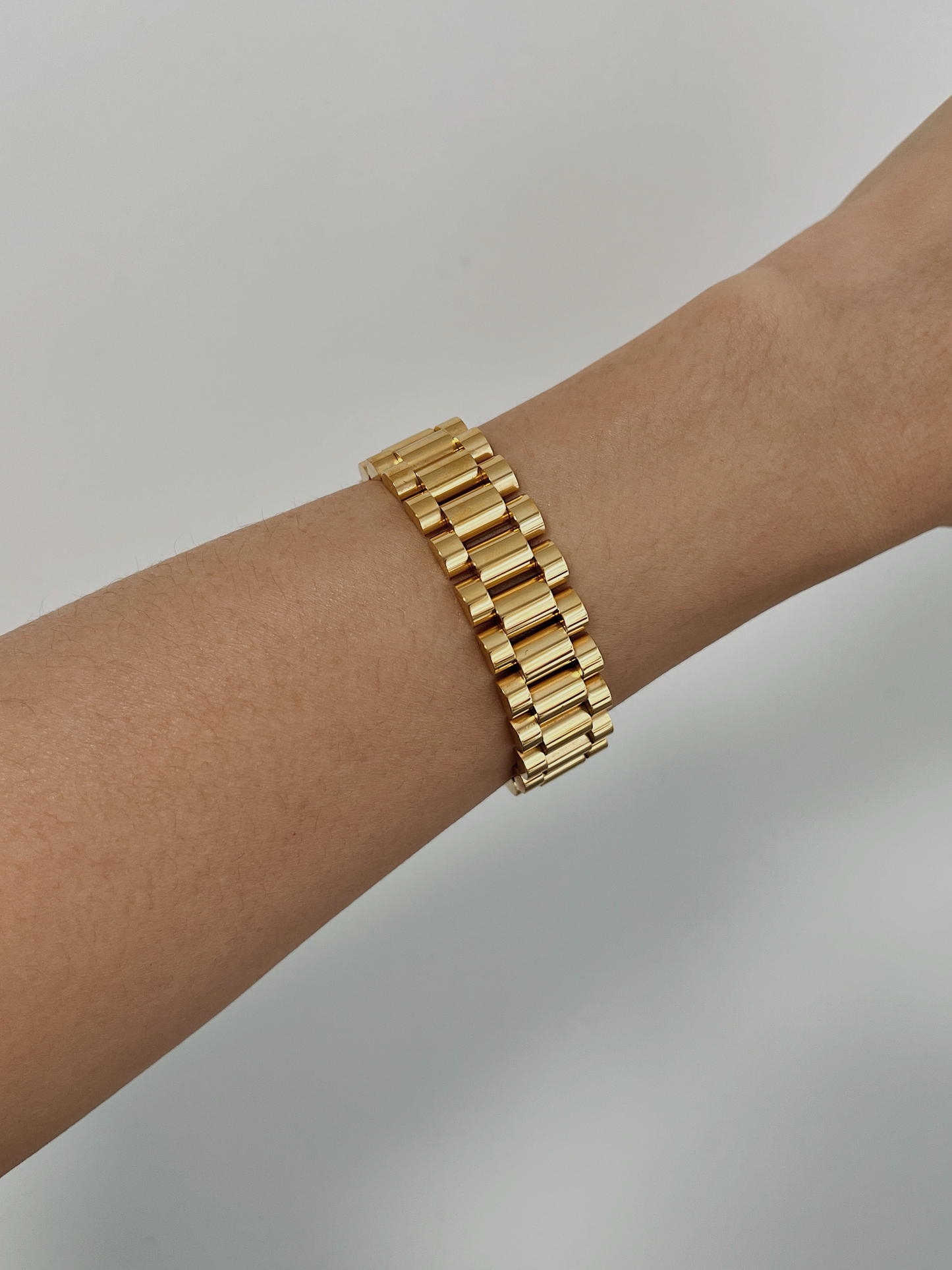 Elegant 15mm standard width Spencer watch link chain bracelet in gold on a wrist, shot against a clean light background.