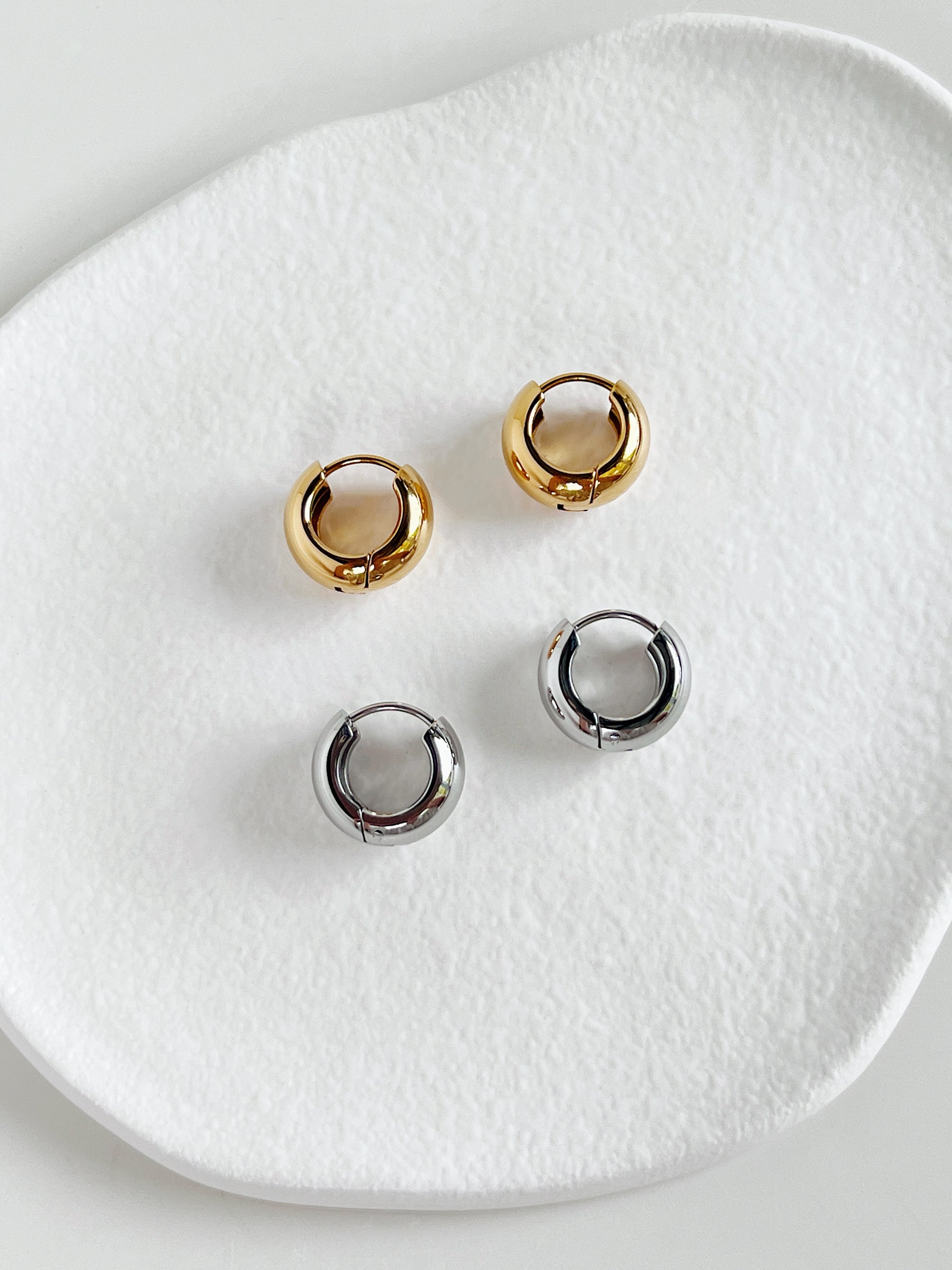 Amie Chunky Huggie Hoops in 18k Gold PVD & Stainless Steel on white background.