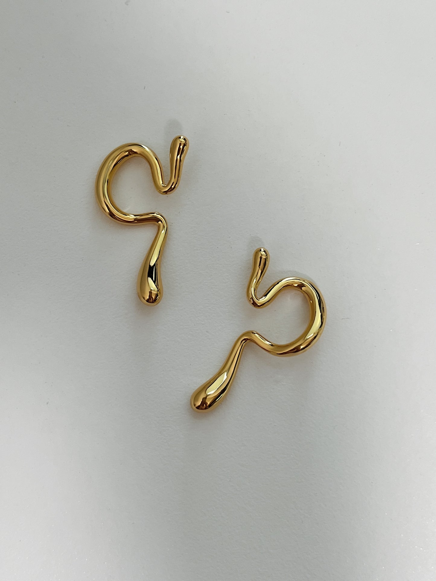 Waterproof 18K gold PVD jewelry for unpierced ears showcasing molten form.