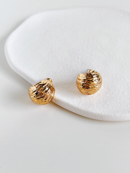 Top-down view of Mira Gold Hoops on a white surface showing tactile ripple texture