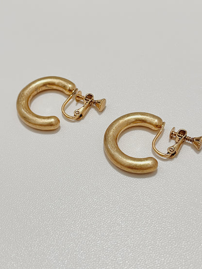 Technical close-up showing the premium adjustable screw hinge backing of the gold Zora clip-on hoop earrings.