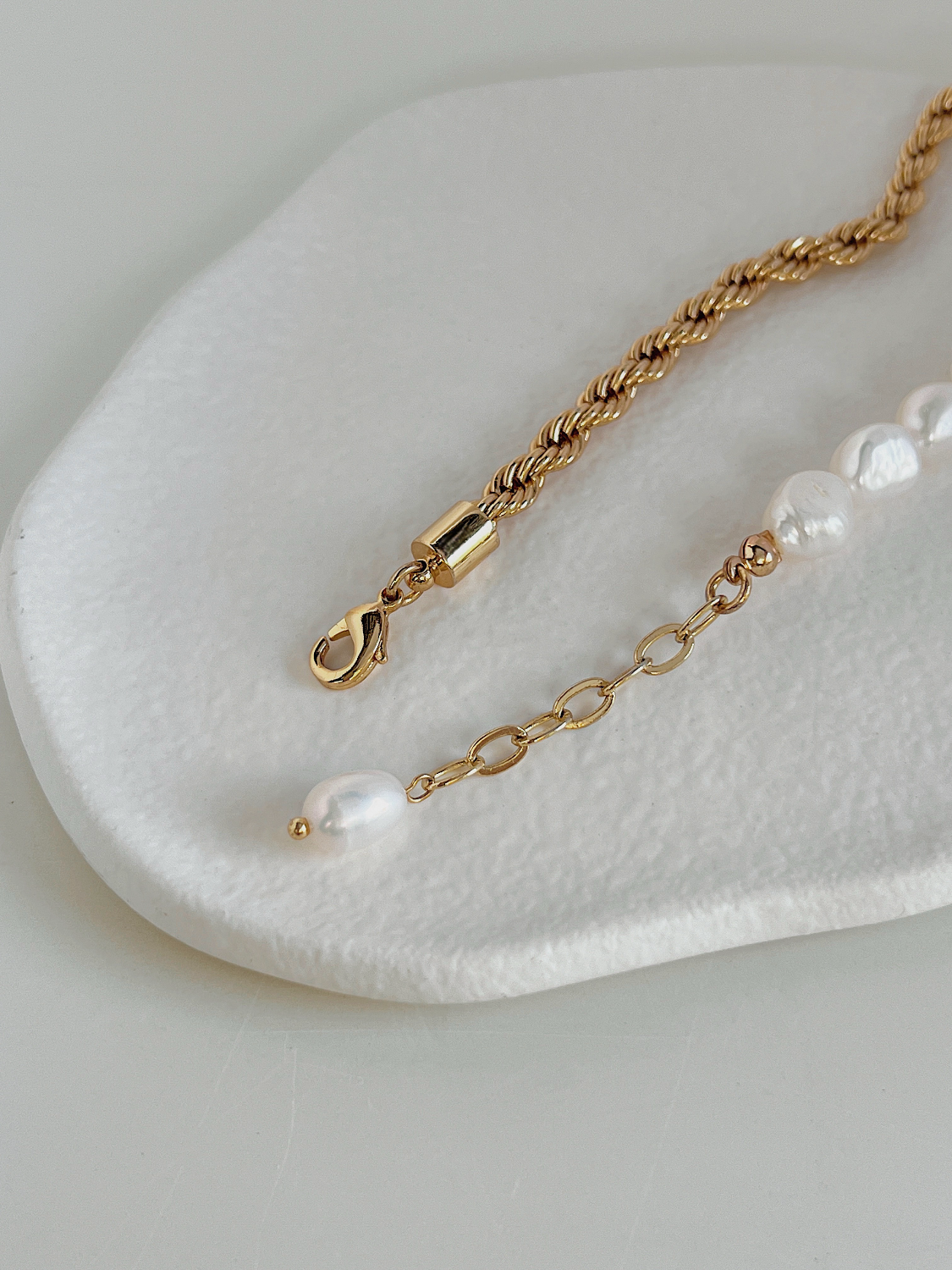 Back detail of jewelry extender chain and lobster clasp with tiny baroque pearl accent