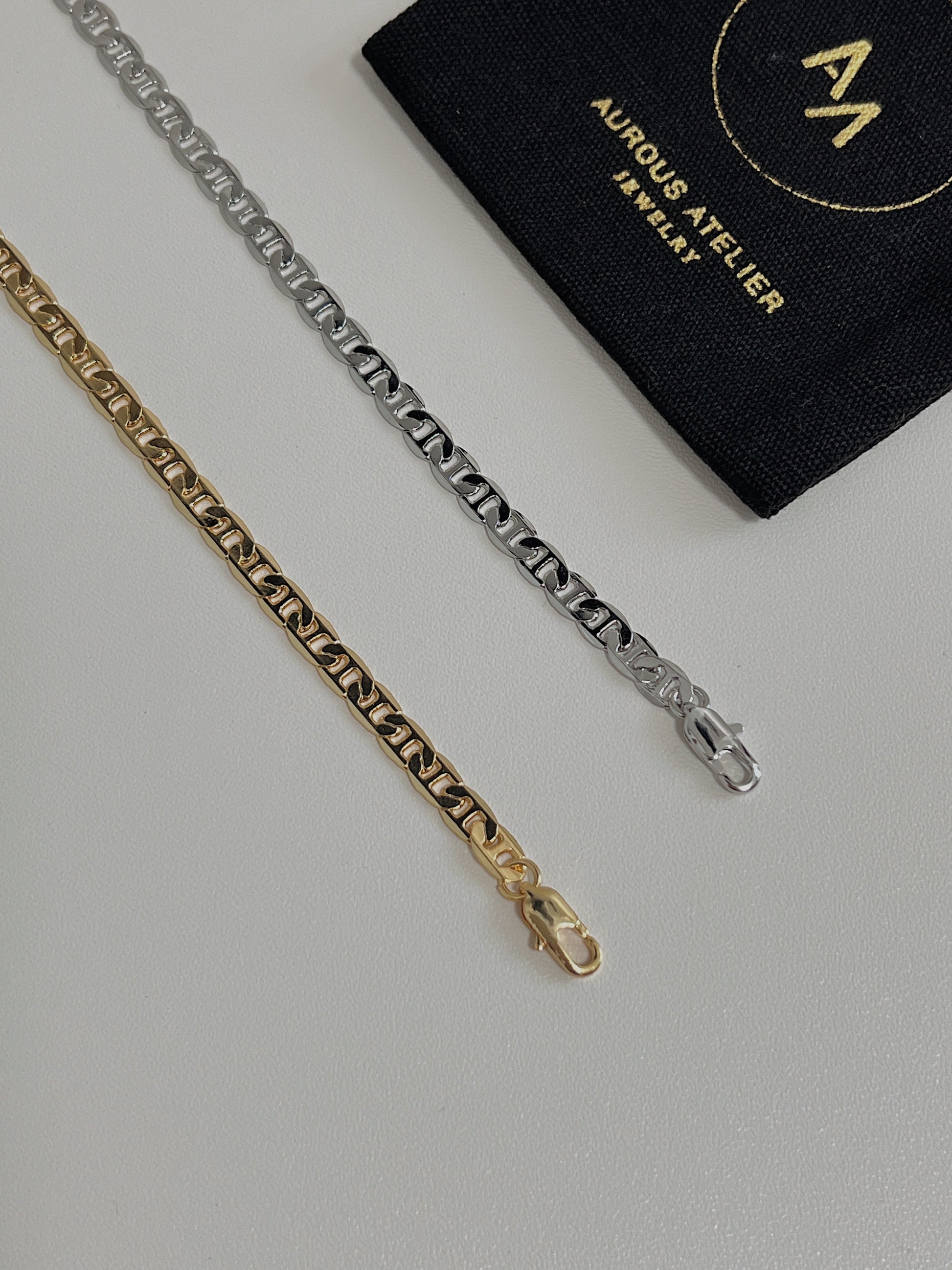 Overhead view of the Alba mariner chain necklace highlighting its 4mm flat-milled geometric profile on a white background
