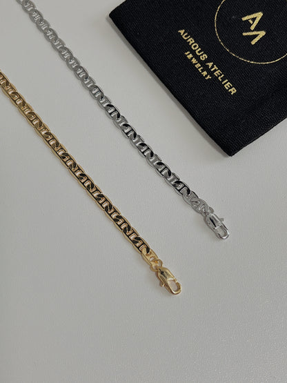 Overhead view of the Alba mariner chain necklace highlighting its 4mm flat-milled geometric profile on a white background