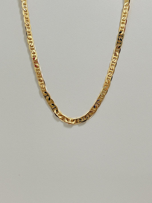 Studio view of the Alba mariner chain necklace showing its flat 4mm gold geometric link profile on a white leather background