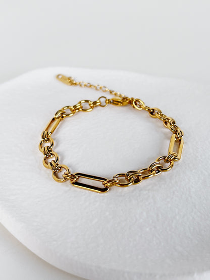 The Alyssa structural link bracelet laid  on a neutral background to illustrate the precise alternating rhythm of the long links and small rings.