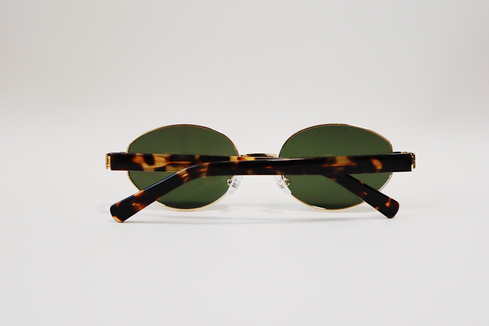 Macro detail shot of the Amalfi sunglasses focusing on the wide, substantial tortoiseshell acetate side arms and gold hinge alignment.