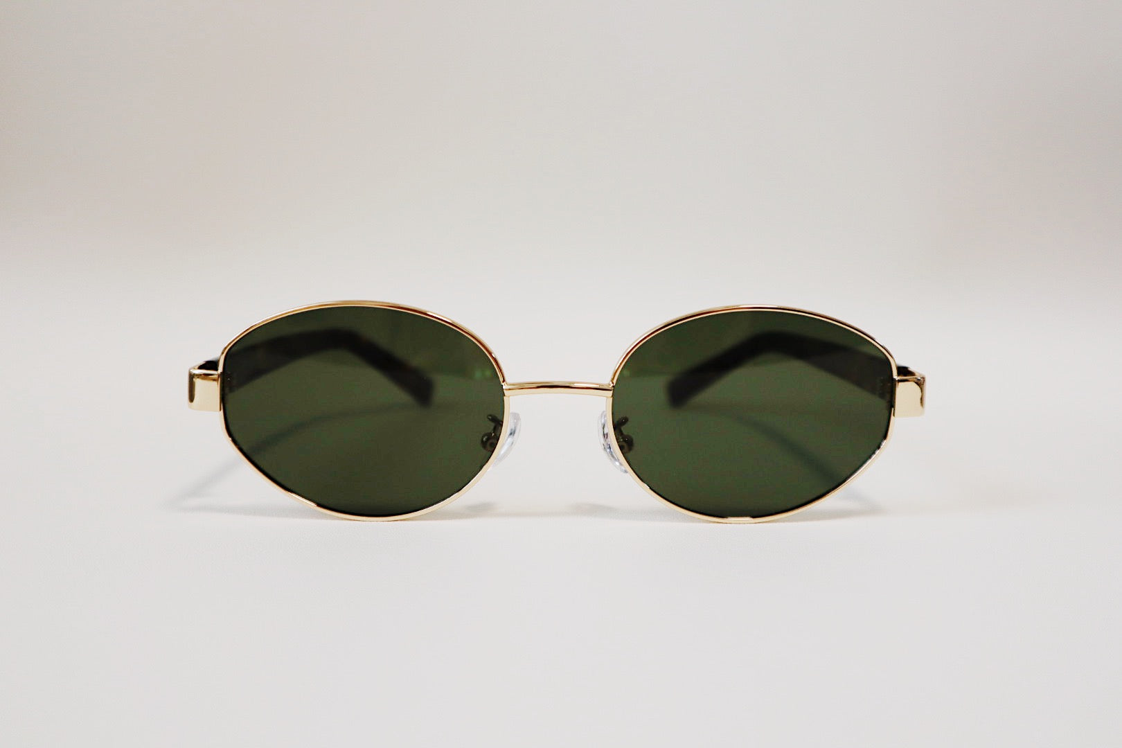 Flat front-facing studio view of the Amalfi oval sunglasses, showing the exact symmetrical balance of the fine gold metal wire frame.