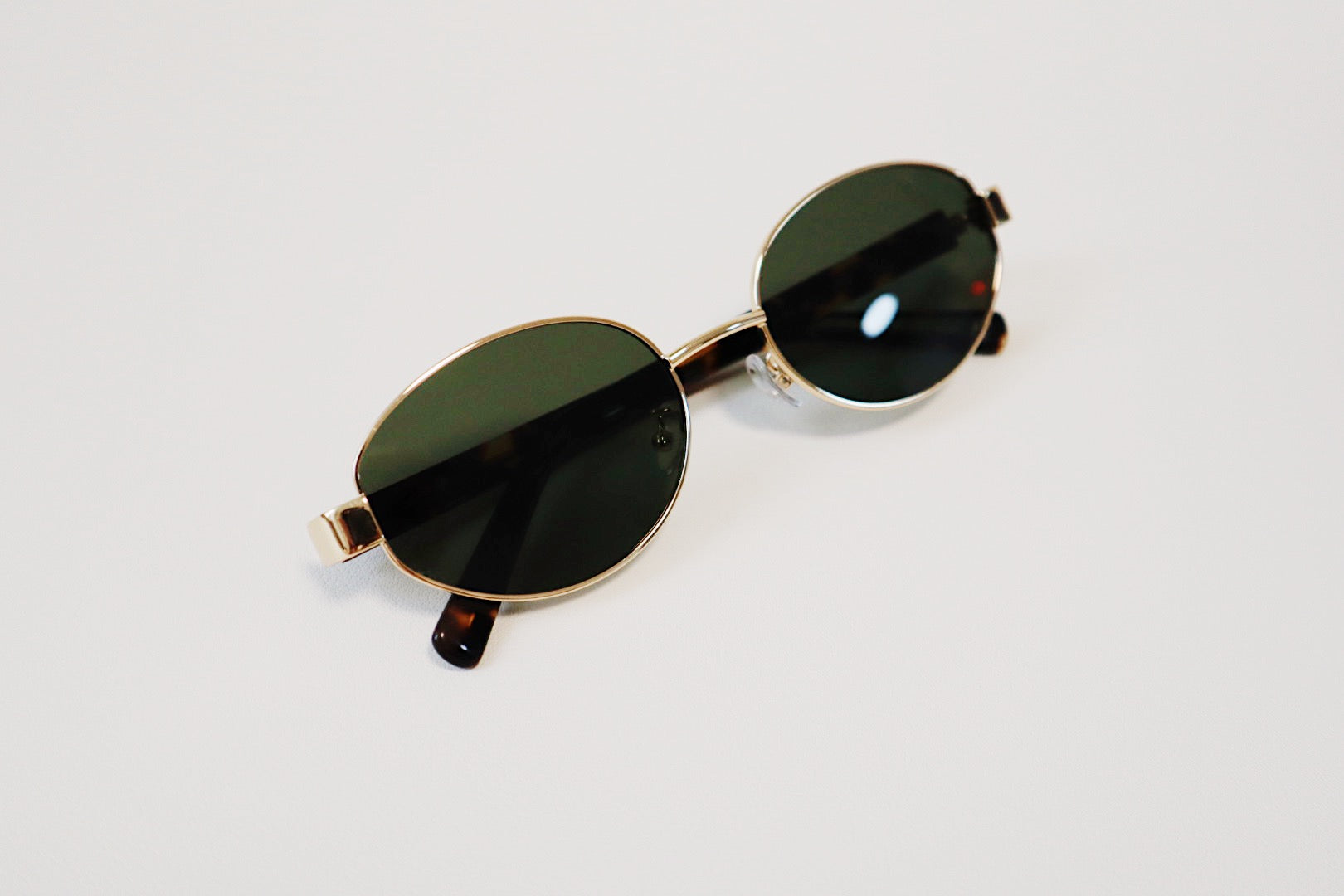 Close-up studio detail of the Amalfi frames, highlighting the rich, uniform opacity of the solid bottle-green lenses under direct lighting.