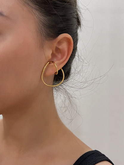 Close-up of model's ear showing the secure fit of the geometric cuff.