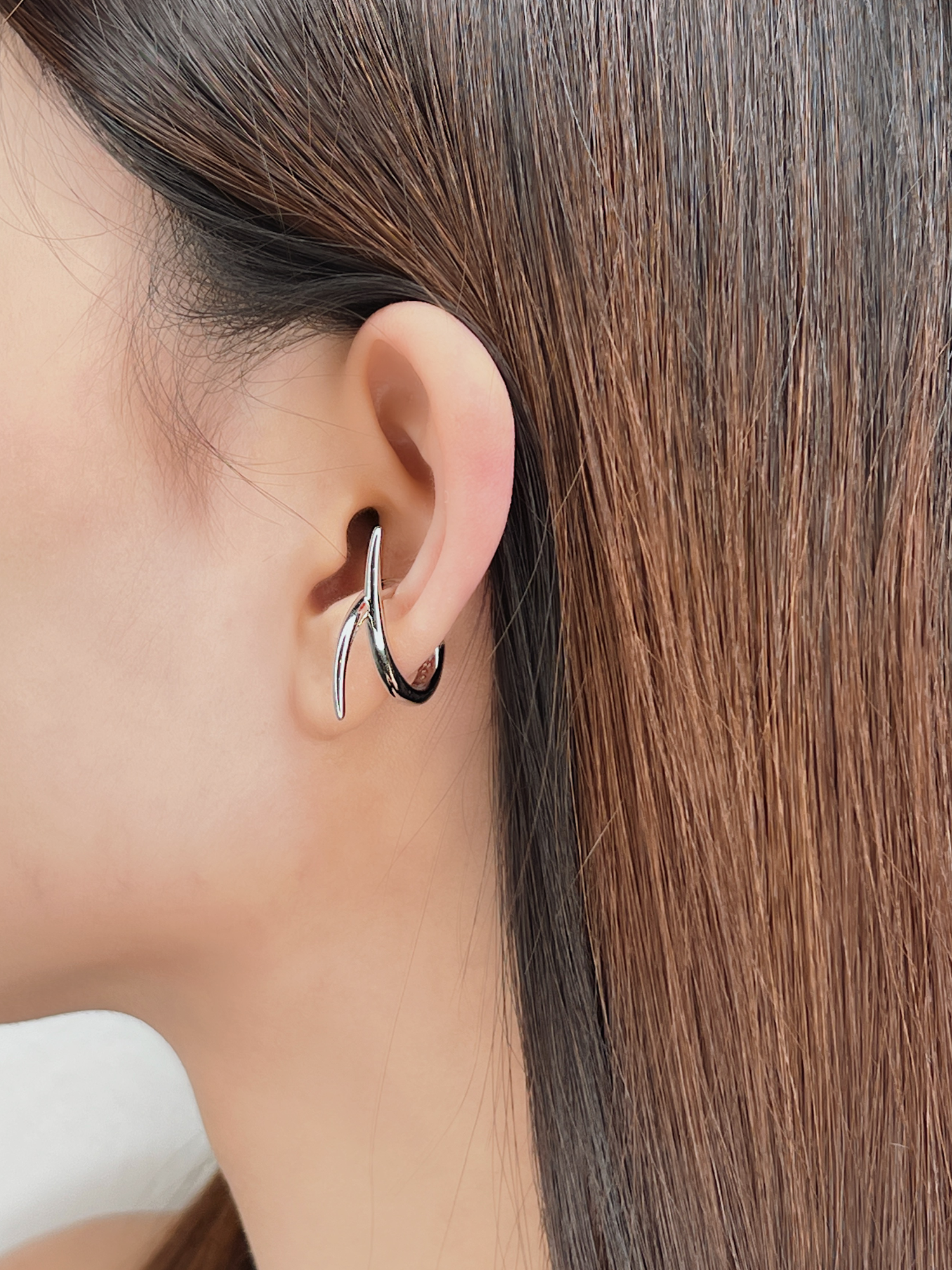 Profile view of model wearing the Harley cuff to show how the "X" shape contours the ear.