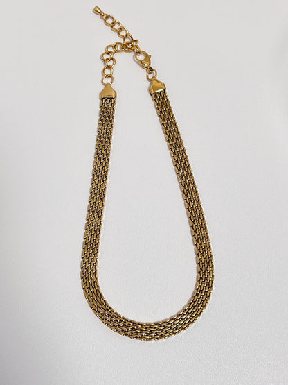 Symmetrical layout of an architectural 8mm woven gold chain highlighting its fluid fabric like flexibility