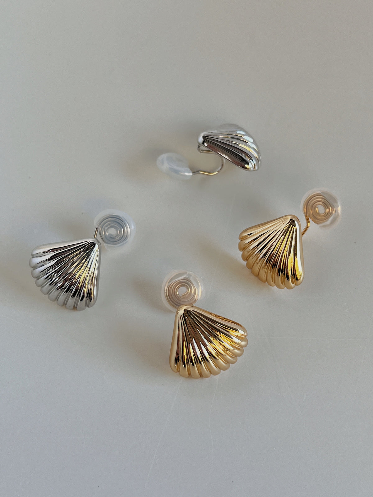 Close up view of transparent silicone comfort cushion on spiral wire clip of Ariel non-pierced shell stud