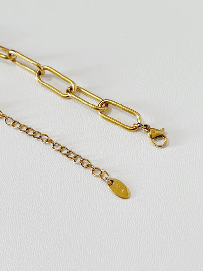 Close-up macro shot of the Asher necklace closure mechanism, highlighting the sleek, unadorned gold lobster clasp and minimalist extender chain link structure.