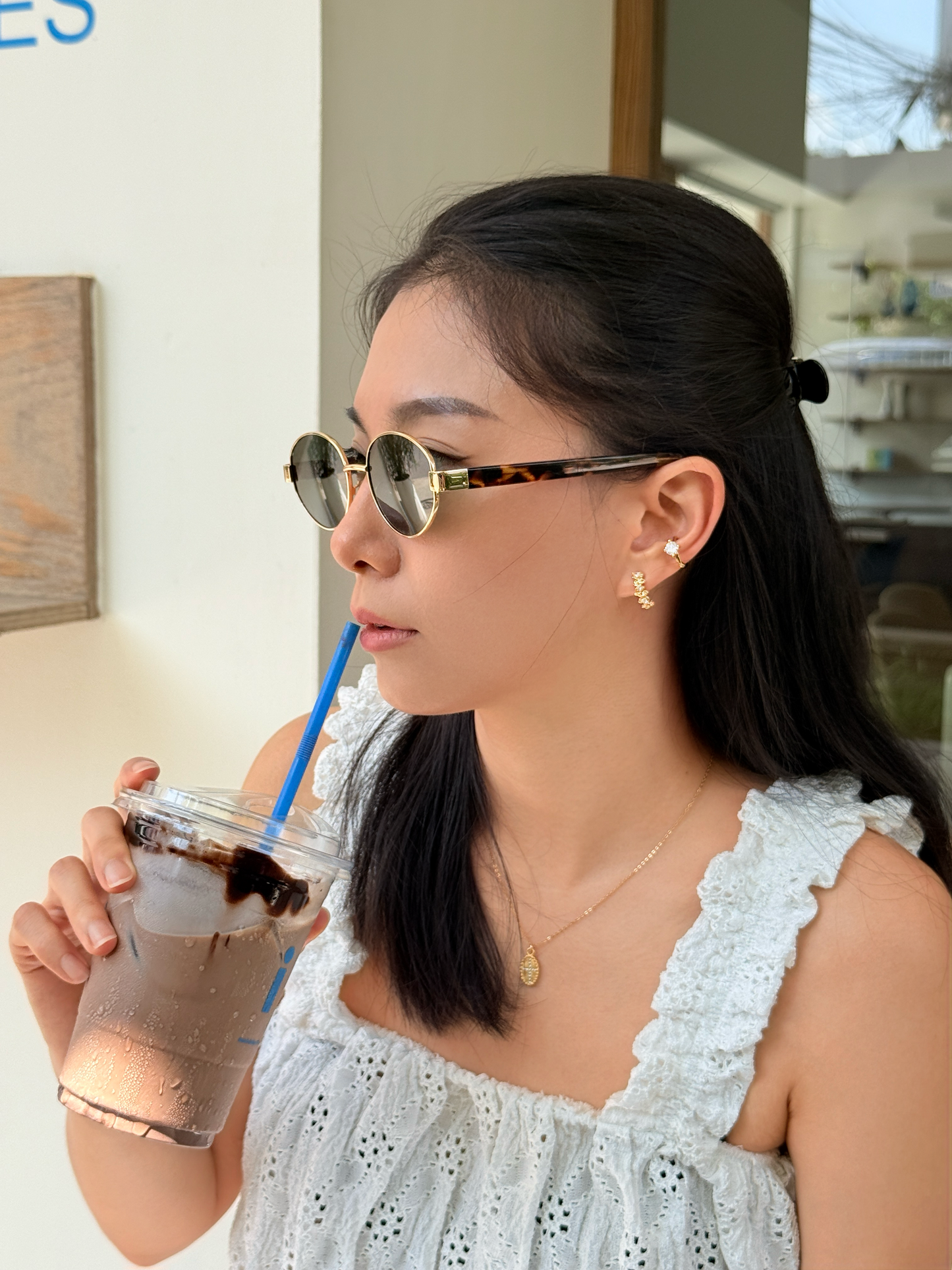 Aspirational wardrobe capture showing a model styling non-pierced climber clip-on earrings with a cute white lace blouse