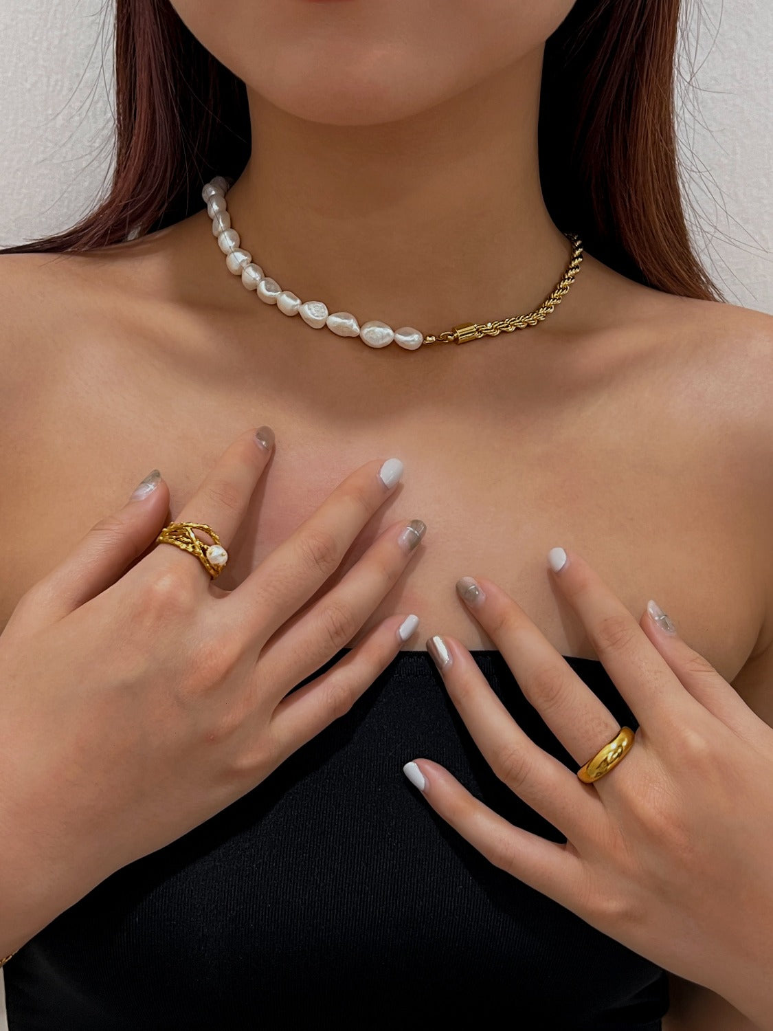 Editorial styling of a mixed texture half chain pearl necklace on a female profile