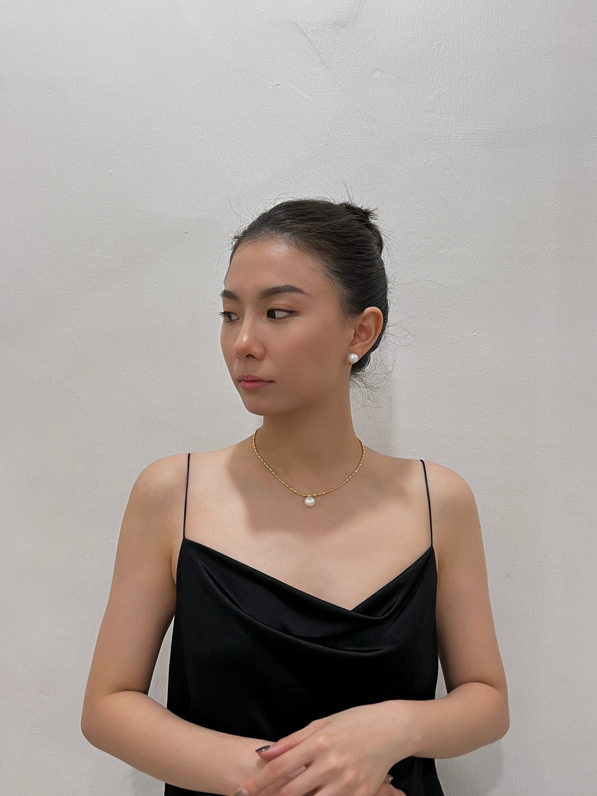 Three-quarter side profile showing scale and flush earlobe placement of 10mm high-lustre pearl clip-on stud earrings.
