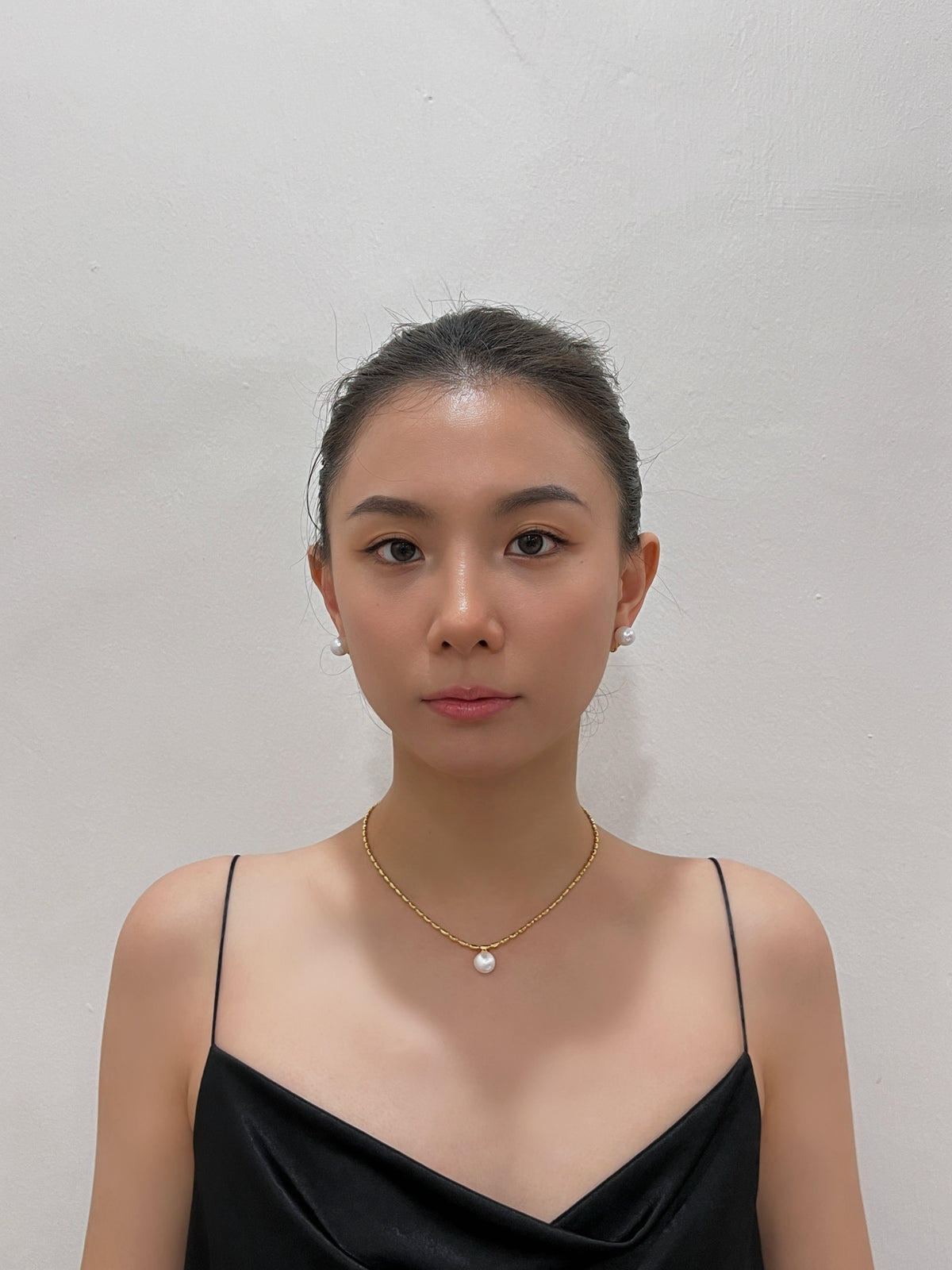 Direct frontal portrait highlighting the smooth iridescence and mirror-like lustre of 10mm floating pearl clip-on studs.