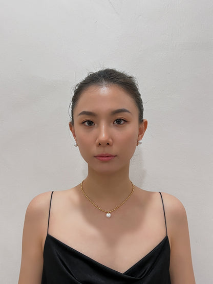 Direct frontal portrait highlighting the smooth iridescence and mirror-like lustre of 10mm floating pearl clip-on studs.