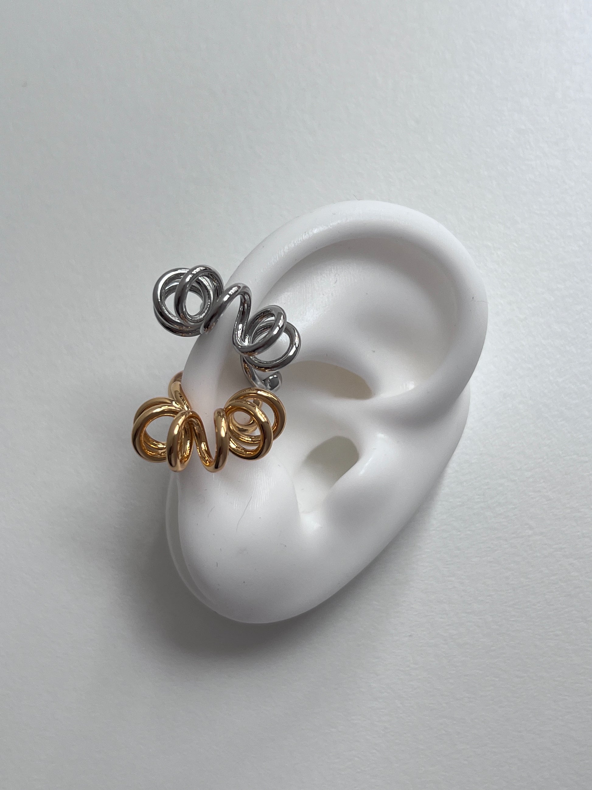 Gold and silver Lis cuffs side-by-side to highlight the liquid-mirror finish.