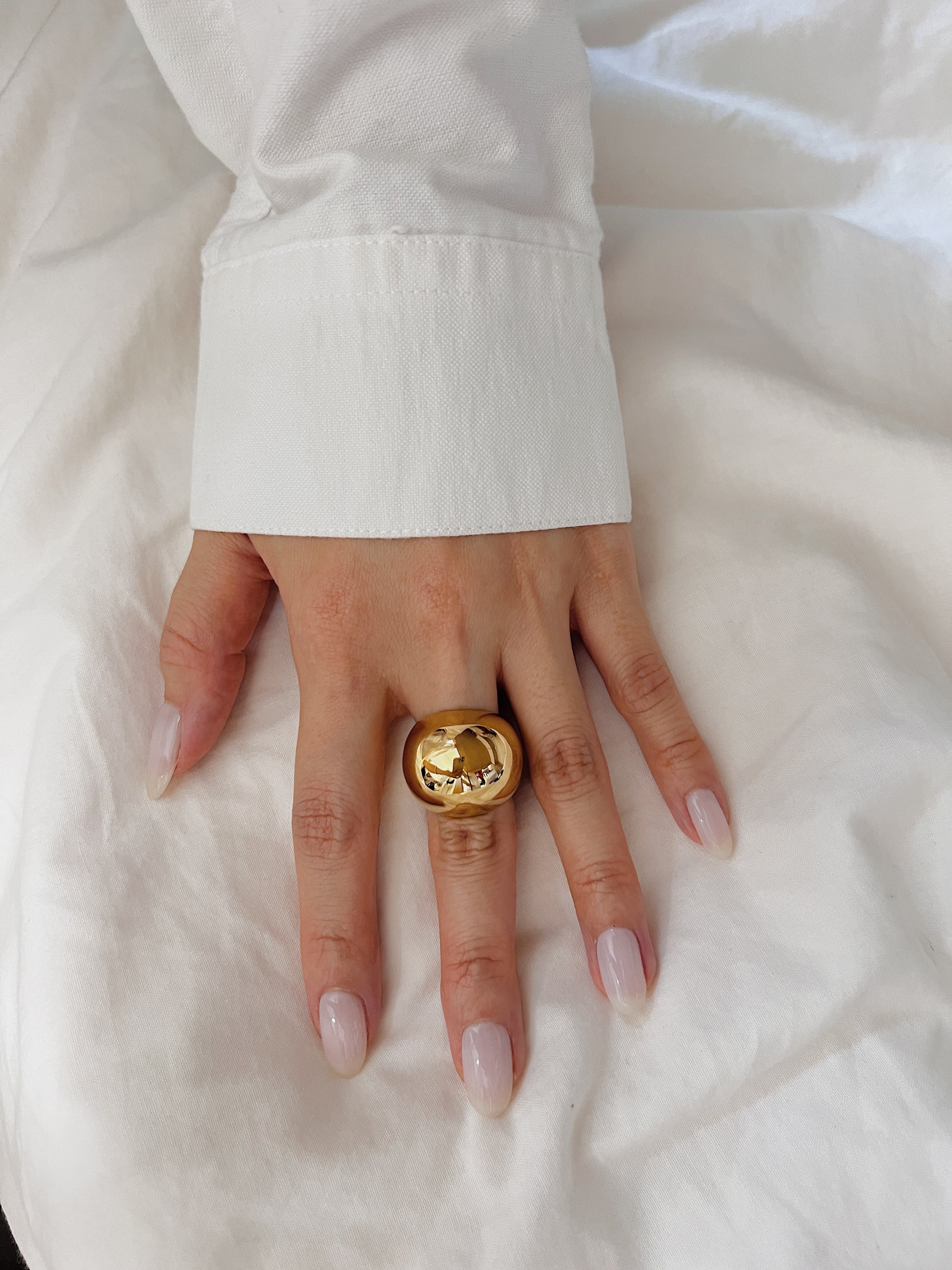 Modern everyday hand stack featuring a bold gold ring on the middle finger