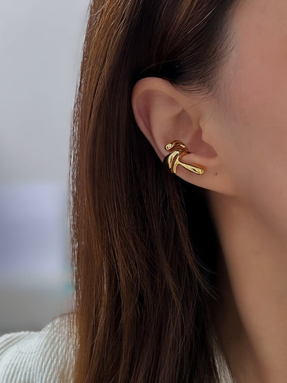 Side profile of a model featuring a curated ear stack with gold abstract cuffs.