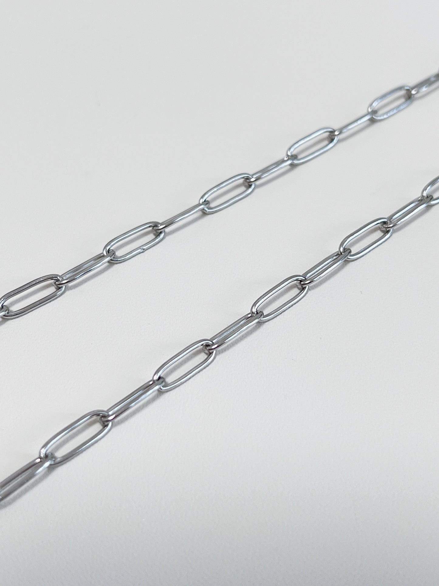 Aurous Atelier independent product display illustrating a flat rectangular outline chain in a icy silver finish