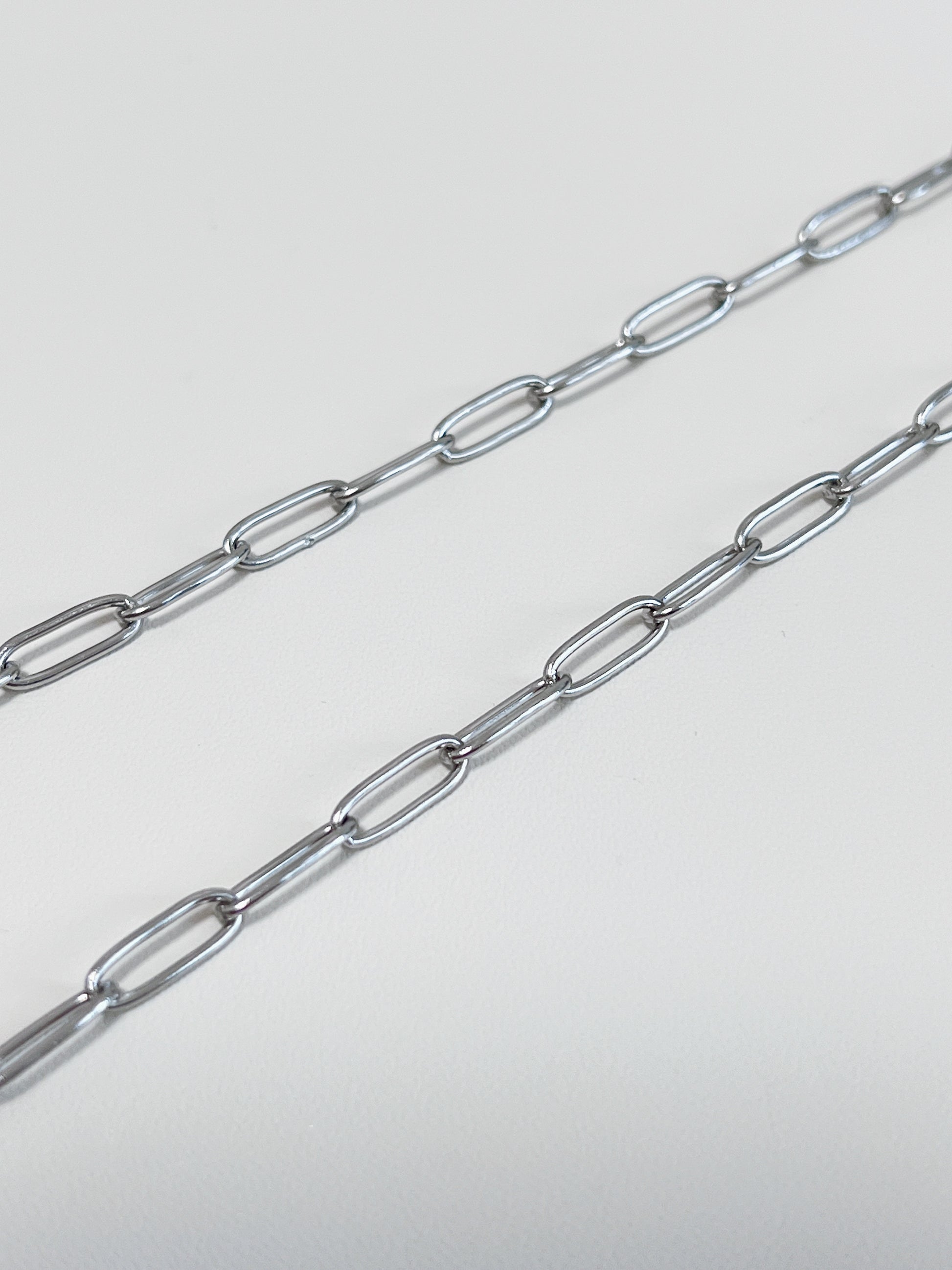 Aurous Atelier independent product display illustrating a flat rectangular outline chain in a icy silver finish