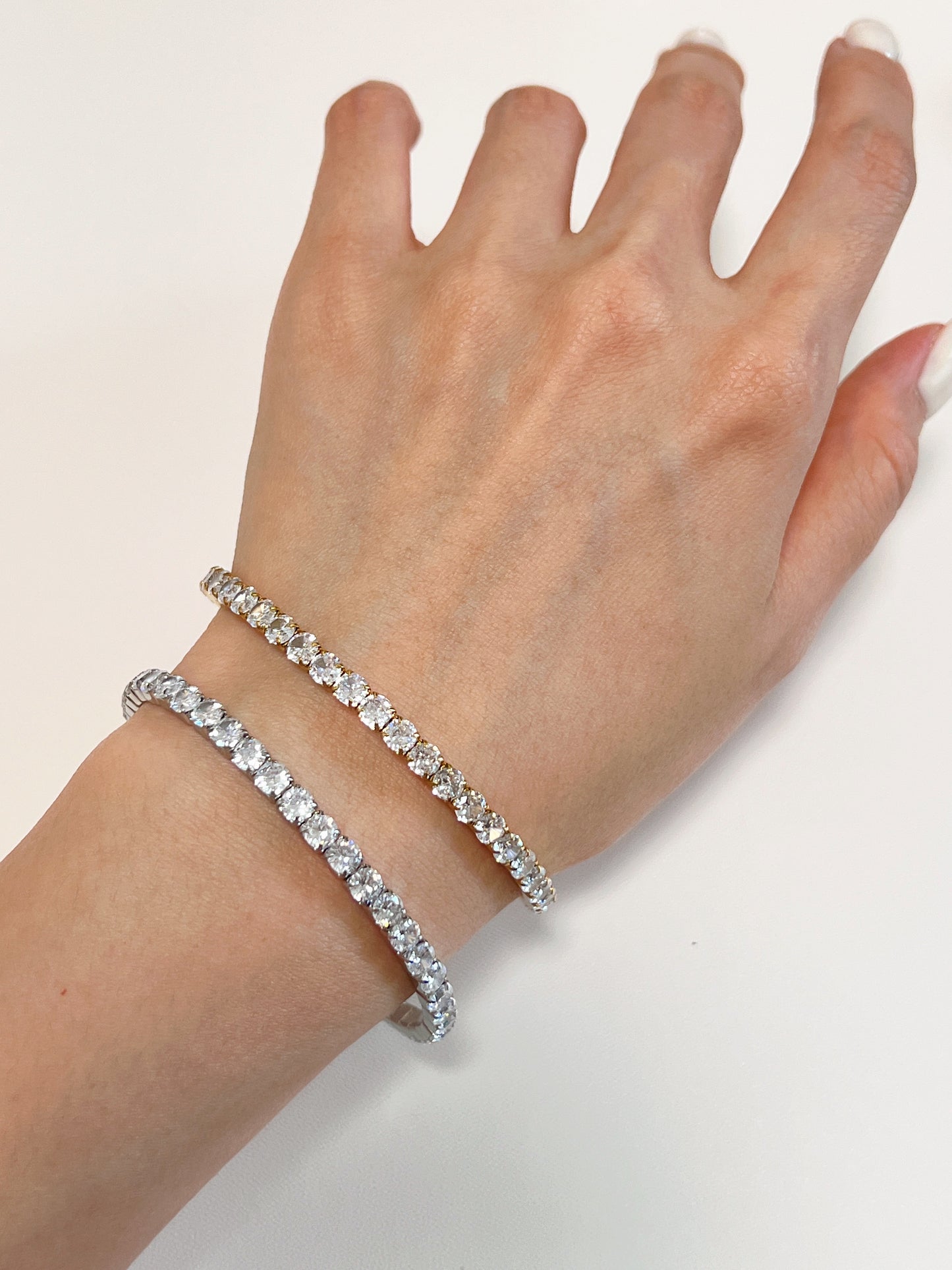 Overhead view of two continuous 4mm diamond tennis bracelets highlighting the precise caliber alignment of the gemstones.