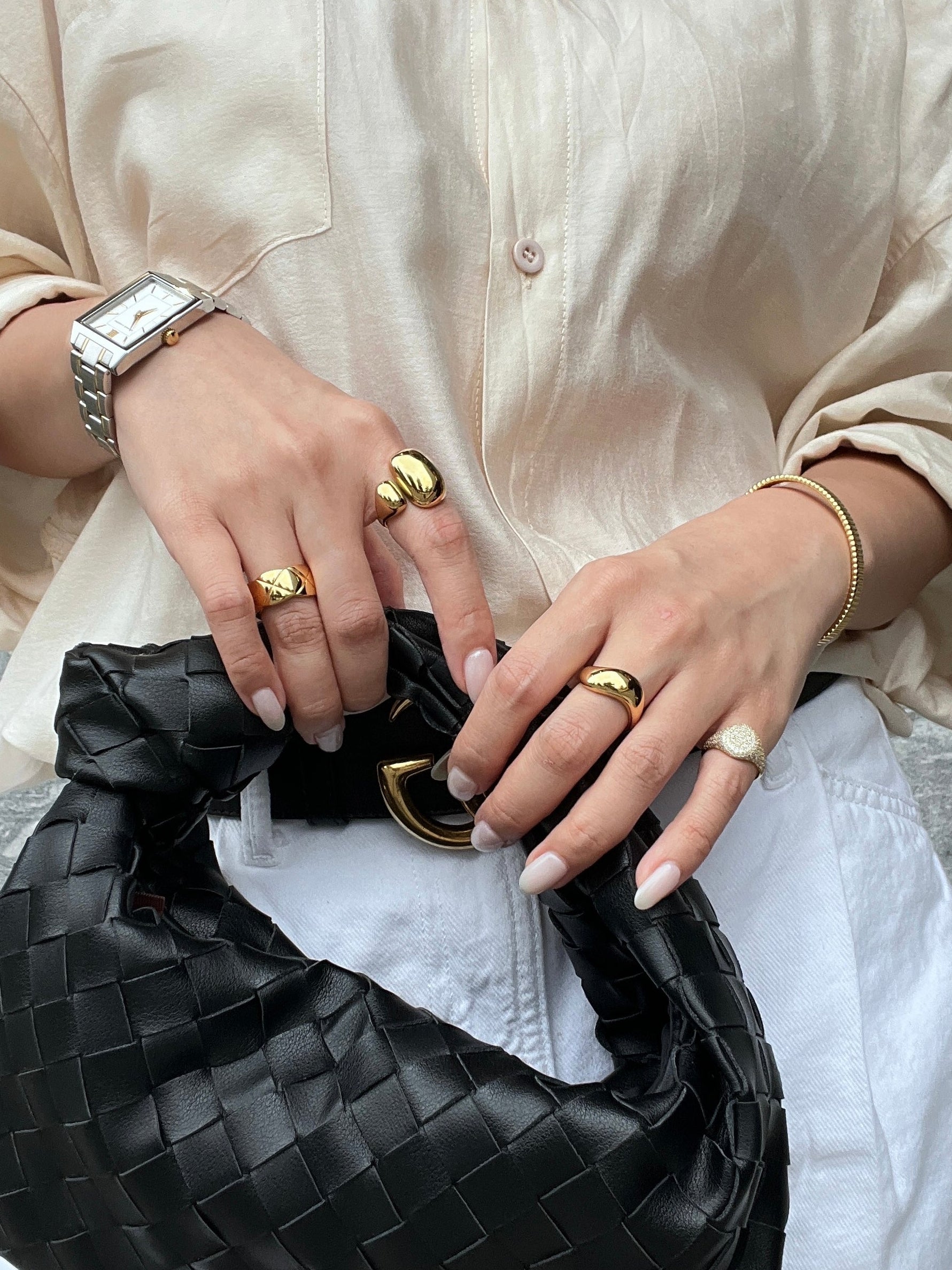High-mirror gold sculptural ring catching light on model's finger
